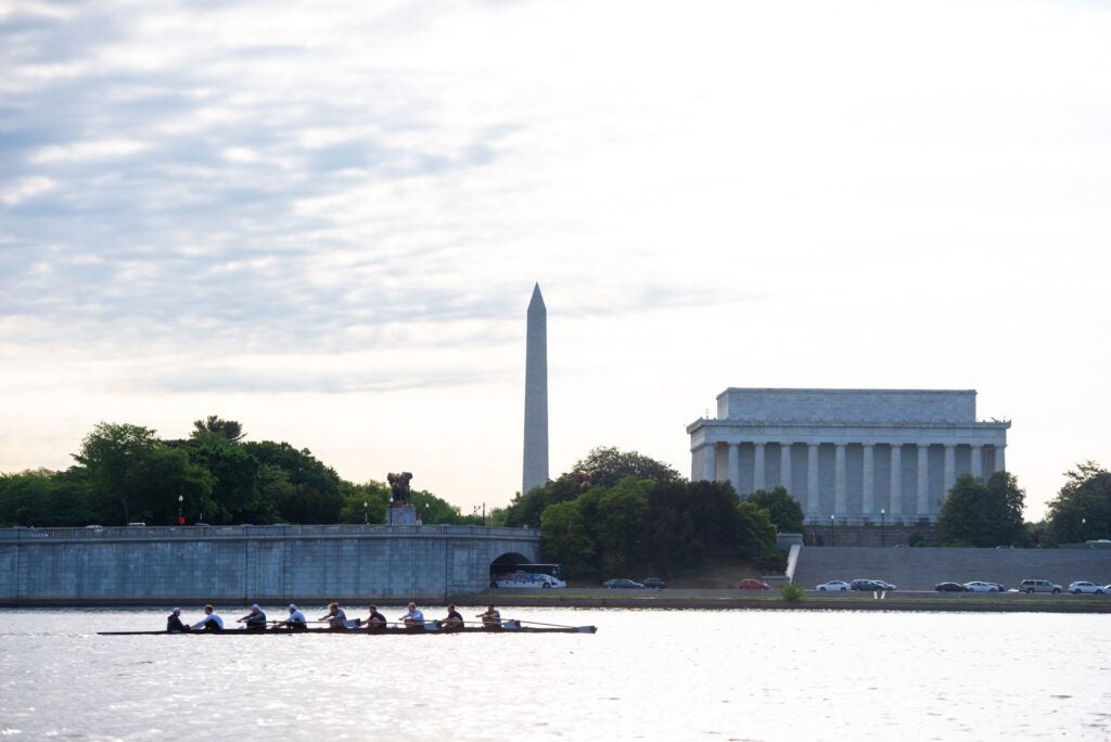 view of Lincoln Memorial and Washington monument from the Potomac river. A crew team rows in the foreground