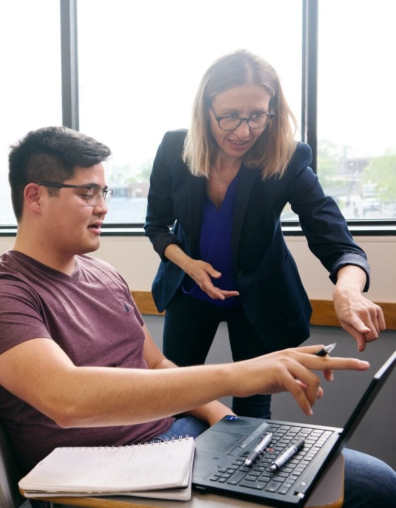 Instructor showing a student something on a laptop